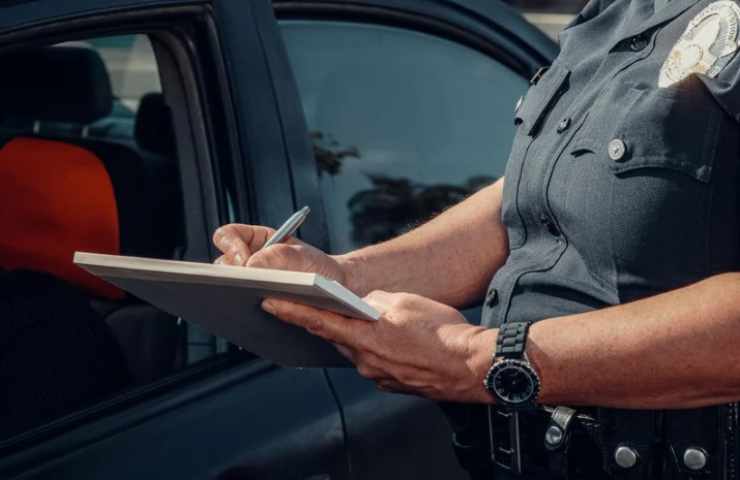 Poliziotto con taccuino ferma auto 
