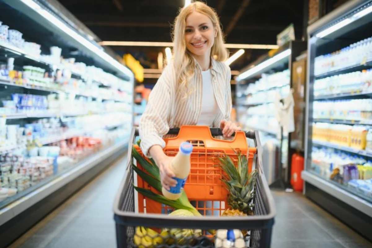 Donna tra le corsie del supermercato fa la spesa