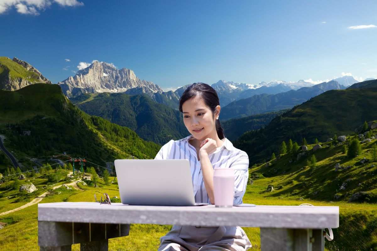 Donna in smart working con un paesaggio di montagna 